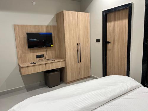 a bedroom with a bed and a cabinet with a television at hotel a sons in Chittaurgarh