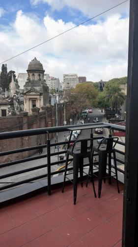a table and chairs on a balcony overlooking a city at MONS hostel in Buenos Aires