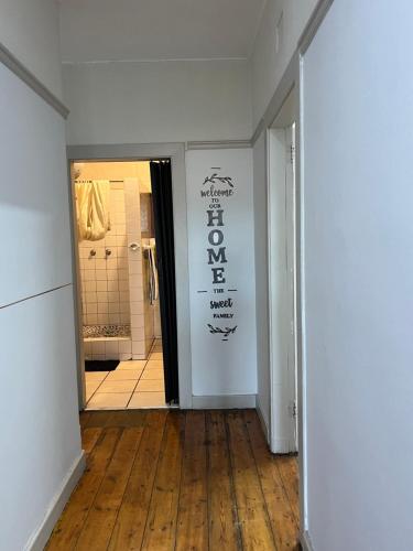a hallway with a white room with a sign on the wall at The Willow Whispers guest house in Gqeberha