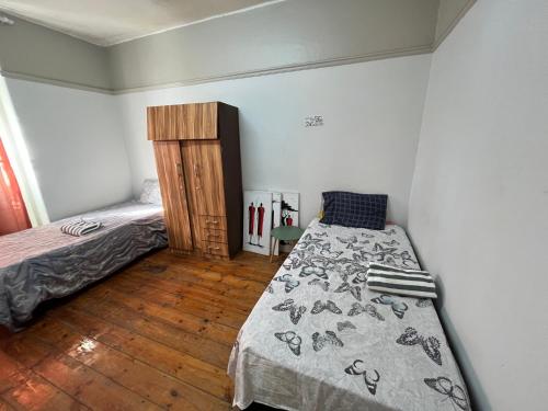 a bedroom with a bed and a wooden floor at The Willow Whispers guest house in Gqeberha
