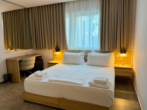 a hotel room with a bed with towels on it at Giulia Center Hotel in Tirana