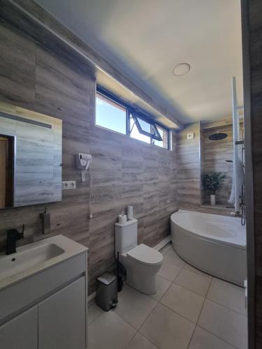 a bathroom with a tub and a toilet and a sink at Verde Resort in Ikalto