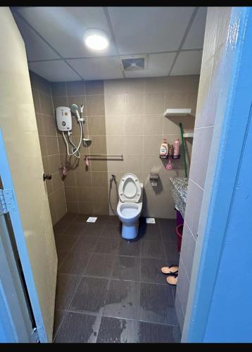 a bathroom with a toilet with the seat up at Tiara Homestay Desaru - Garden Pool View in Bandar Penawar