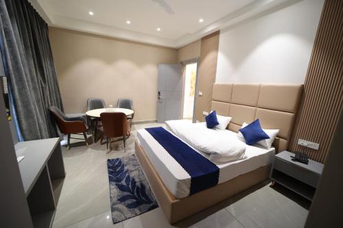 a bedroom with a bed and a table and chairs at Hotel Vantara in Karnāl