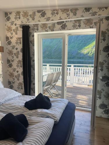 a bedroom with a bed and a sliding glass door at Senja Aurora Lodge in Senja