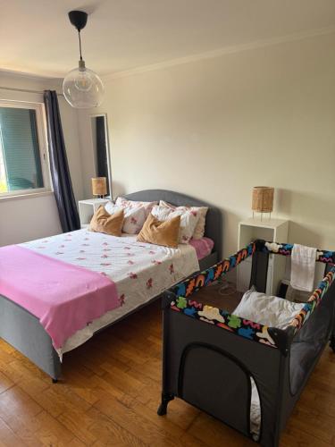 a bedroom with a bed and a crib in it at Aroeira Elite Apartments in Aroeira