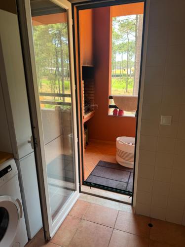 a bathroom with a toilet and a glass door at Aroeira Elite Apartments in Aroeira