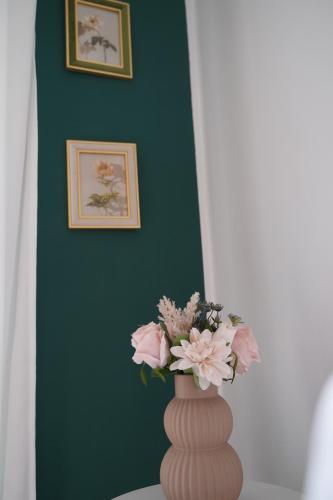 a vase with pink flowers sitting on a table at Titanium in Izola