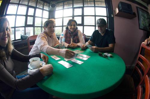 a group of people sitting around a table playing cards at Hotel y Hosteria Natabuela in Natabuela