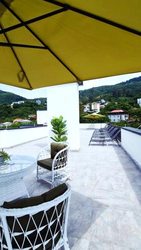 a patio with chairs and a yellow umbrella at PARALLEL Apartments in Gonio