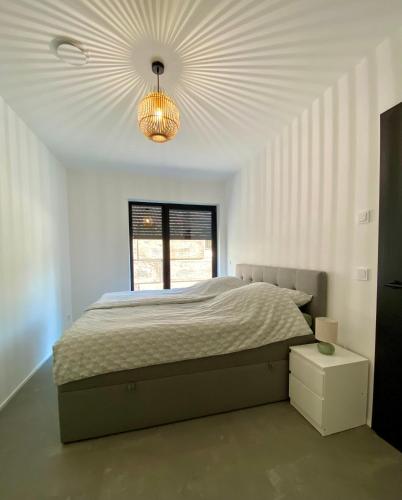 a bedroom with a large bed and a chandelier at Hedwig und Paul in Mehring