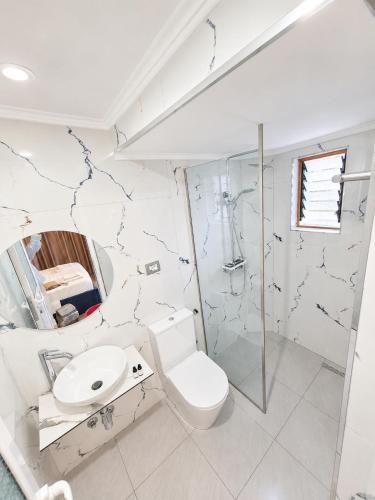 a white bathroom with a toilet and a sink at Vasiliu Boutique Hotel Ksamil in Ksamil