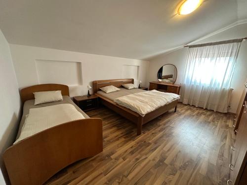 ein Schlafzimmer mit zwei Betten und einem Spiegel in der Unterkunft Catana in Arad