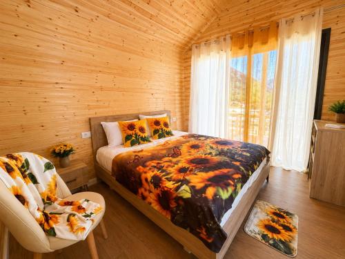 ein Schlafzimmer mit einem Bett und einem Stuhl in einem Zimmer in der Unterkunft Lean chalet Sea&Mountain view in Dukat