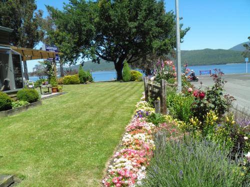 a row of flowers in a park near the water at Lakefront Lodge in Te Anau