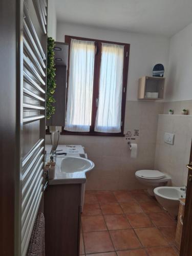 a bathroom with two sinks and a toilet and a window at Castello Vignola in Vignola
