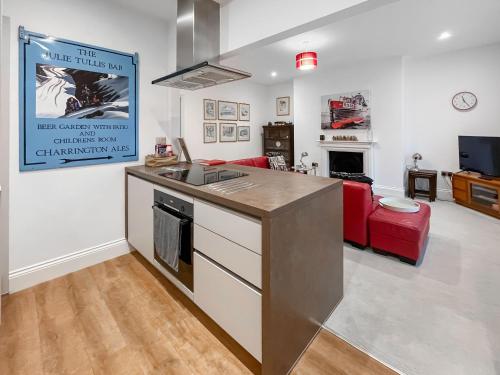 a kitchen with a counter top and a living room at Rooftops No83 in St. Leonards