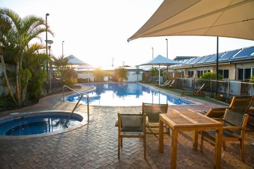 a patio with a table and chairs next to a pool at Nesuto Geraldton in Geraldton