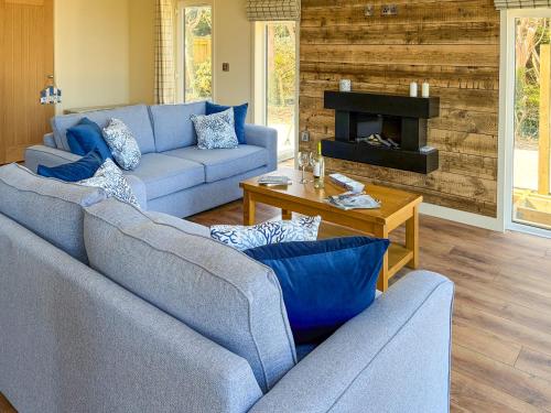 a living room with blue couches and a fireplace at Lodge 4 - Uk51095 in Perranporth