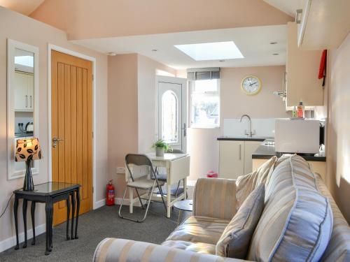 a living room with a couch and a kitchen at Number 150 in Bessingby