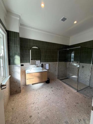 a large bathroom with a sink and a shower at Tourist Hotel Queanbeyan in Queanbeyan