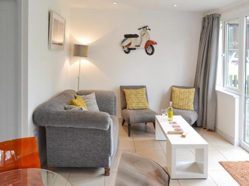 a living room with a couch and a motor scooter on the wall at Happys in St Ives