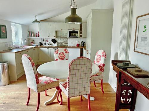 a kitchen with a white table and chairs at The Byre in Rispond
