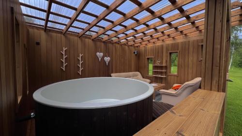 a room with a large white tub and a wooden ceiling at Välgi Puhkepesa in Välgi