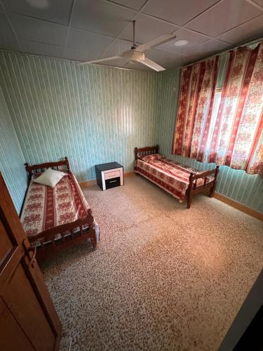 a room with two beds and a table in it at Welcoming Multi-Bedroom House in Duhok