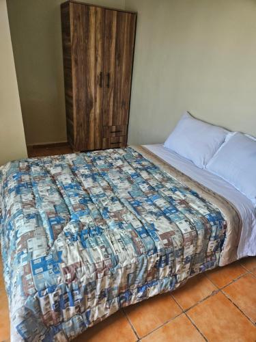 a bed with a quilt on it in a room at Residence Zomroda Sidi Bouzid in Sidi Bouzid
