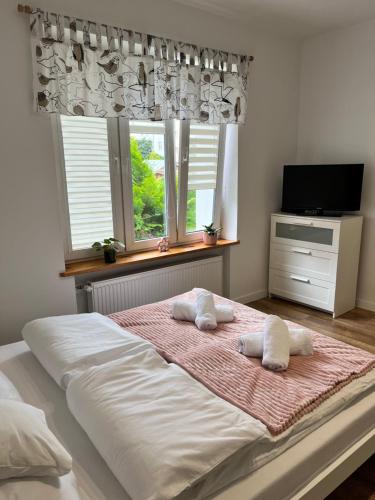 a bedroom with a large bed with two pillows on it at AT Apartament in Pasłęk
