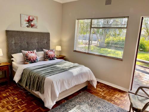 a bedroom with a bed and a window at Karoo Velvet in Beaufort West