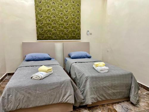 two beds sitting next to each other in a room at Midtown Appart Hôtel in Nouadhibou