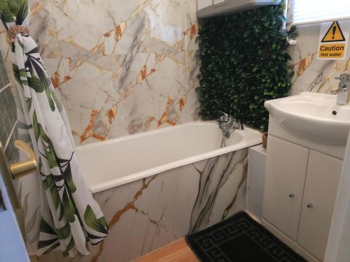 a bathroom with a white tub and a sink at The Lucky 7 in Hemsby