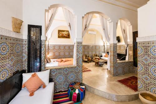 a living room with a couch and mirrors at Riad Olivier Marrakech medina in Marrakesh