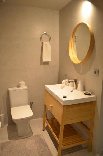 a bathroom with a toilet and a sink and a mirror at Downtown apartment - Signature in Kamena Vourla