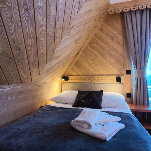 a bed with two towels sitting on top of it at Jedla Miejsce Gościnne blisko term in Bukowina Tatrzańska