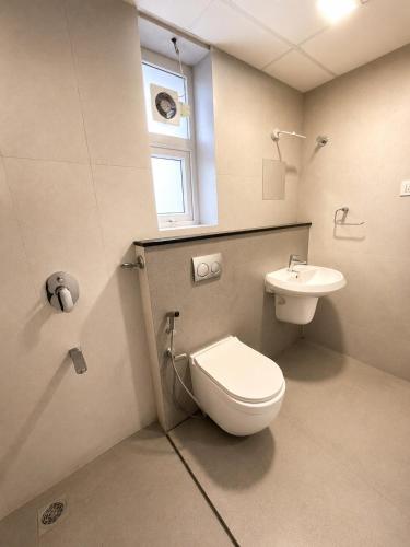 a bathroom with a toilet and a sink at Mirage 8D Inn in Vythiri