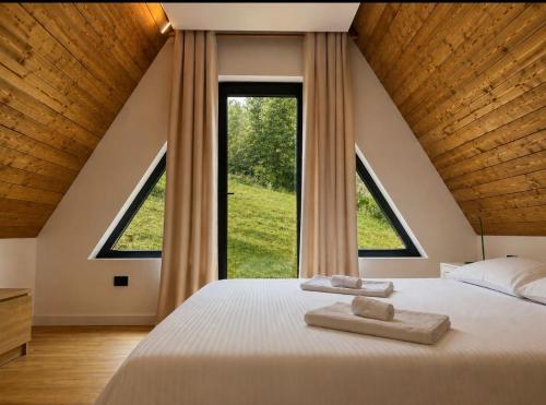 a bedroom with a large bed with two towels on it at Riverside A-frame in Borşa