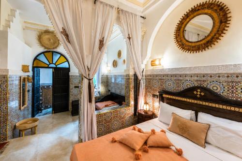 a bedroom with a bed and a mirror at Riad Olivier Marrakech medina in Marrakesh