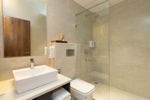 a bathroom with a sink and a shower and a toilet at The Aralia in Dehradun