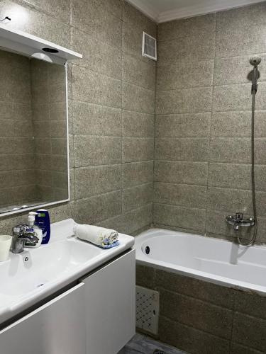 a bathroom with a tub and a sink and a shower at Spacious and sunny comfy apartment in Oran