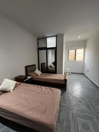 a bedroom with two beds and a large mirror at Spacious and sunny comfy apartment in Oran