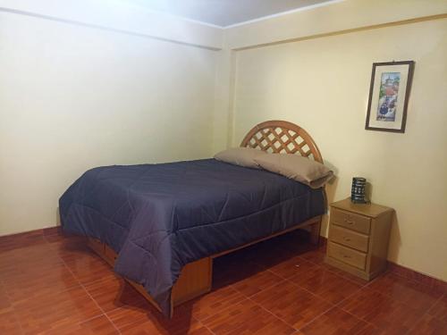 a bedroom with a bed and a night stand at Shekina Huaraz Departament in Huaraz