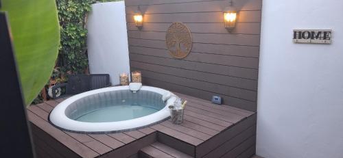 a hot tub on a wooden deck with a house sign at Angels Pathway con Jacuzzi in Fátaga