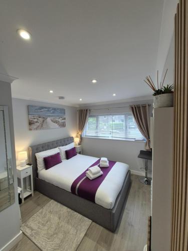 a bedroom with a large bed with purple pillows at Pro Stay Studio in Fort William