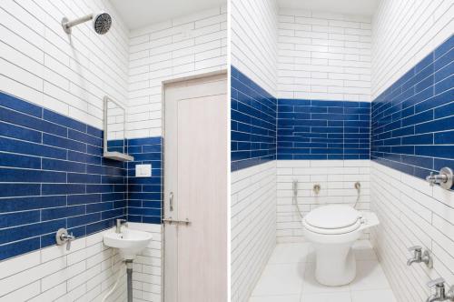 a blue and white bathroom with a toilet and a sink at Hotel Kalyan in Rajkot
