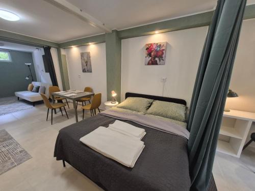 a bedroom with a bed and a dining room at Da Vinci Apartmanok in Eger
