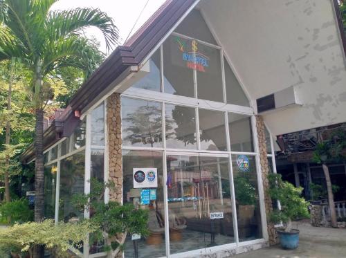 a store front with large glass windows and palm trees at Sikatel Hotel in Batac