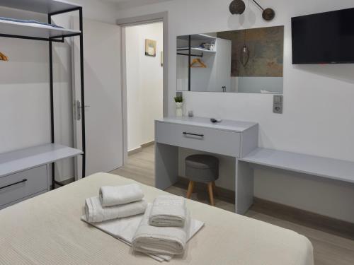 a bedroom with a bed with a desk and a mirror at Otium Studios in Limenaria